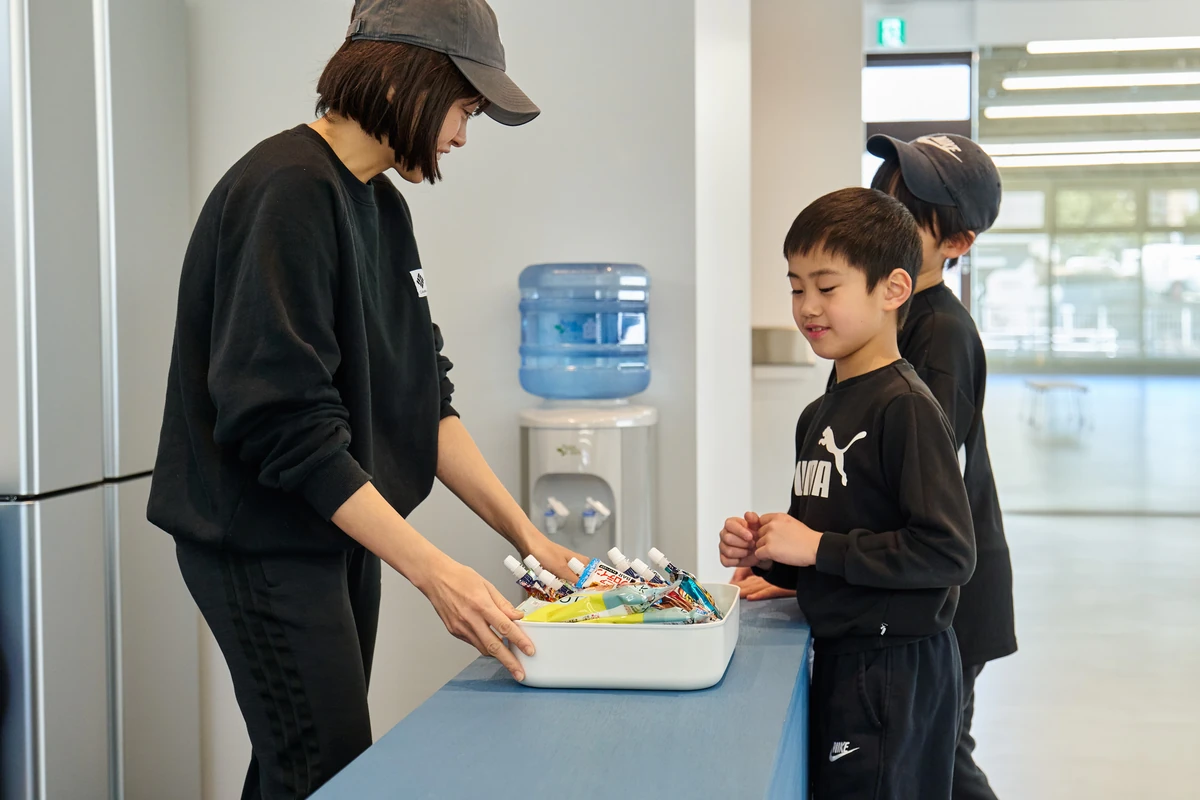 先生からおやつを受け取る子どもたち